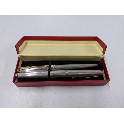 124 - A mixed lot of pens to include a boxed Cross ballpoint pen with box, a silver coloured Parker ballpo... 