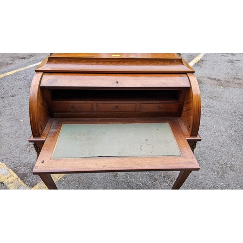 220 - A late 19th century French mixed veneered cylinder desk with gilt metal mounts, with a fitted interi... 