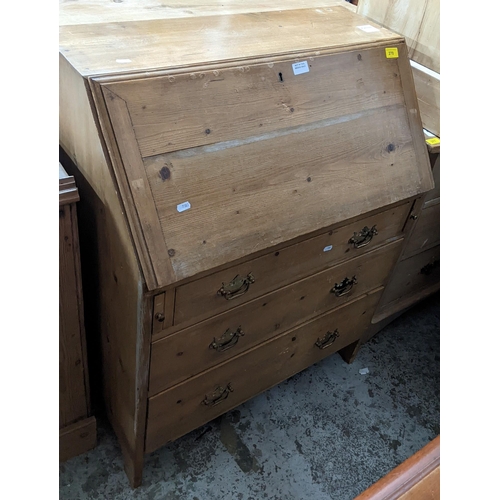 270 - A 20th century pine bureau with fall flap revealing a pigeonhole interior, over one short and two gr... 