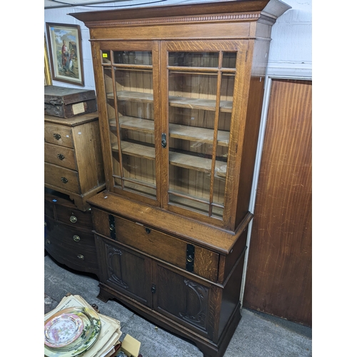 319 - A Victorian oak bookcase secretaire, the top with dentil moulded cornice above twin glazed doors and... 