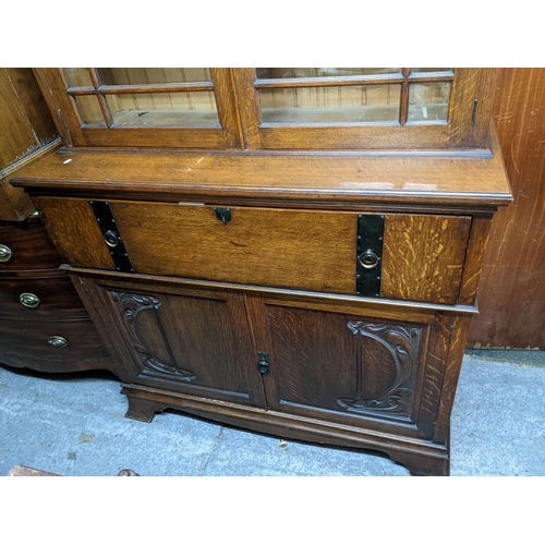 319 - A Victorian oak bookcase secretaire, the top with dentil moulded cornice above twin glazed doors and... 