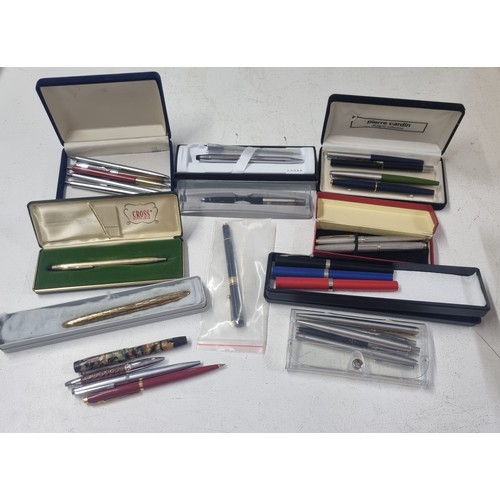 124 - A mixed lot of pens to include a boxed Cross ballpoint pen with box, a silver coloured Parker ballpo... 