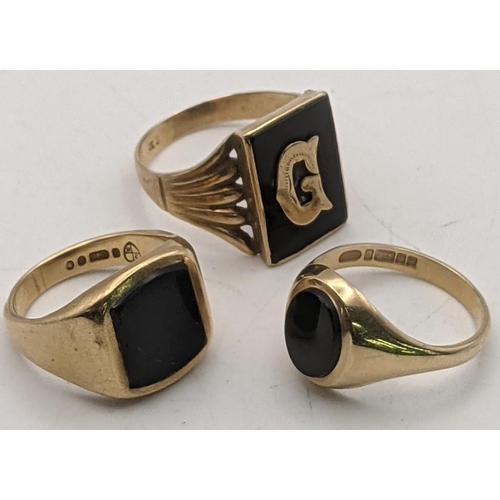 40 - Three 9ct gold and black onyx gents signet rings to include one set with the letter G, size T, anoth... 