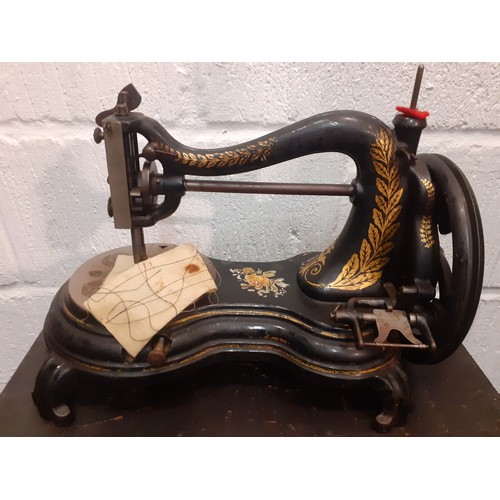 73 - Circa 1890's, a Jones hand cranked sewing machine having a serpentine swan neck  with wooden case an... 