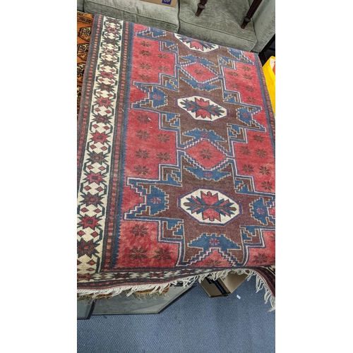 159 - Three rugs to include a Bokhara red ground rug with elephant foot motifs and multiguard borders A/F
... 