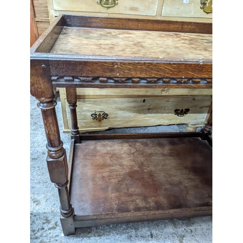 98 - A 20th century pine bureau with fall flap revealing a pigeonhole interior, over one short and two gr... 