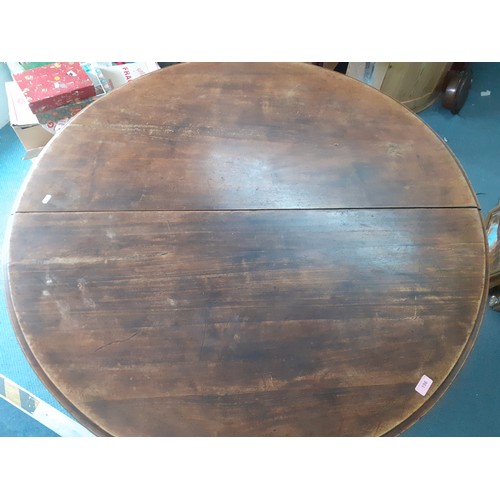 196 - A stained pine circular breakfast table on central carved pedestal support, 29