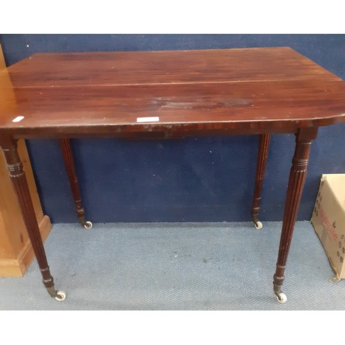 207 - An early 20th century mahogany Pembroke table with drop down sides and fluted legs on castors and an... 