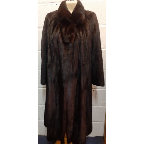 82 - A late 20th Century glossy black mink swing coat having a brown lining with fleur de lys embroidery ... 