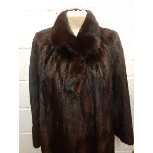 82 - A late 20th Century glossy black mink swing coat having a brown lining with fleur de lys embroidery ... 