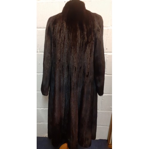 82 - A late 20th Century glossy black mink swing coat having a brown lining with fleur de lys embroidery ... 