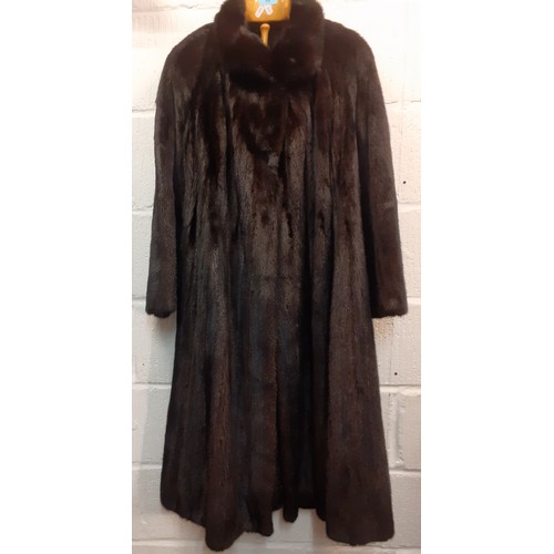 82 - A late 20th Century glossy black mink swing coat having a brown lining with fleur de lys embroidery ... 