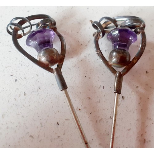 87 - A pair of silver extra long stem hat pins with Scottish thistle design having central purple stones ... 