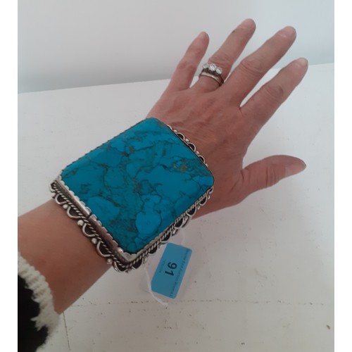 91 - An oversized white metal and turquoise effect cuff bracelet. Location:R1.2