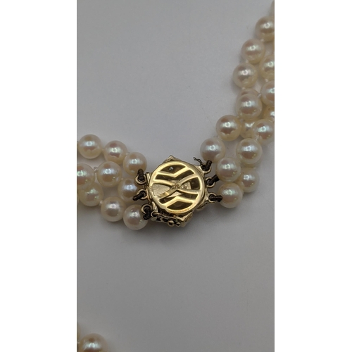 9 - A triple strand pearl necklace having a 9ct gold clasp fashioned as a flower 
Location: CAB
If there... 
