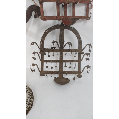 176 - Three Indian wall hanging oil lamp stands together with a wooden carved hanging centrepiece, and one... 