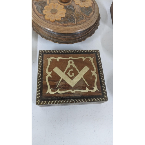 305 - A group of treen boxes to include an Indian deep carved box with hinged lid, a Masonic inlaid box, a... 