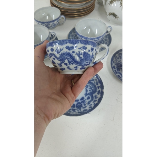 314 - A 20th century Japanese part tea service with a set of 5 blue and white cups and saucers, and others... 