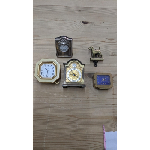 372 - A group of mixed travel clocks to include a Cartier gilt metal octagonal travel clock, a silver face... 