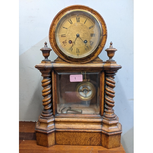 1 - An early 20th century mantel clock with a Roman dial, with a pendulum and key, in a partially glazed... 