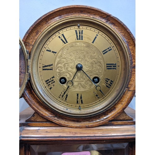 1 - An early 20th century mantel clock with a Roman dial, with a pendulum and key, in a partially glazed... 