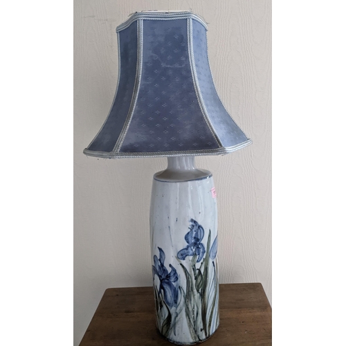 111 - Colin Kellam - a studio pottery table lamp decorated with blue irises, with blue fabric shade, potte... 