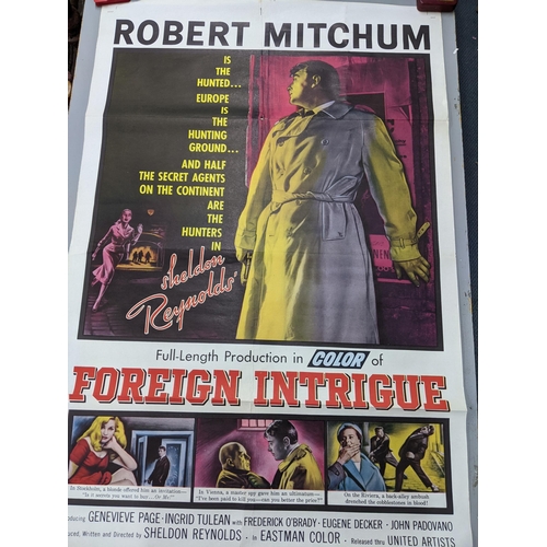 113 - A collection of mainly 1950s/60s and later movie posters unframed to include Robert Mitchum in Sheld... 