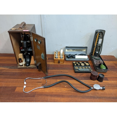 13 - Medicinal equipment to include microscope and a mid century blood pressure machine, weights and a st... 