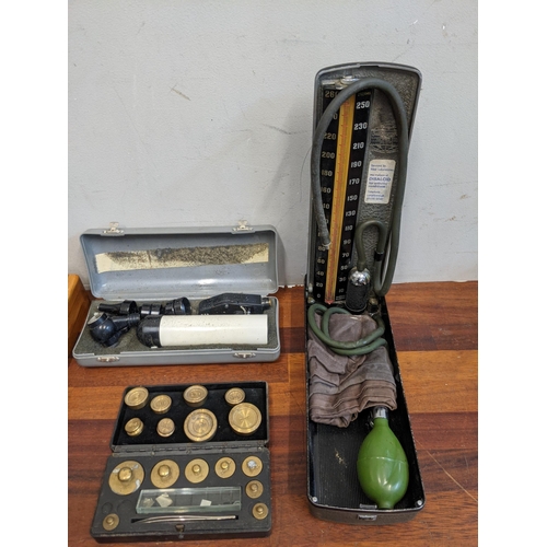 13 - Medicinal equipment to include microscope and a mid century blood pressure machine, weights and a st... 