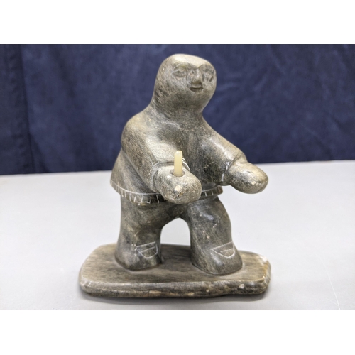 291 - An early 20th century North Canadian Inuit hand carved soapstone figurine holding (possibly) a candl... 