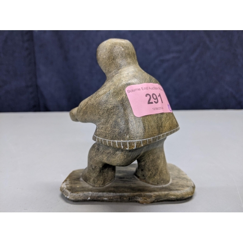 291 - An early 20th century North Canadian Inuit hand carved soapstone figurine holding (possibly) a candl... 