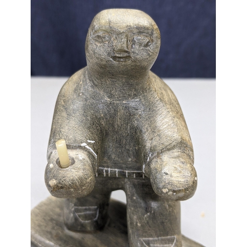 291 - An early 20th century North Canadian Inuit hand carved soapstone figurine holding (possibly) a candl... 