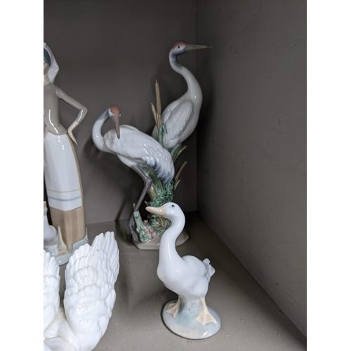 322 - Six Lladro figures to include a model of two storks, a model of a swan, a goose, a girl holding a go... 