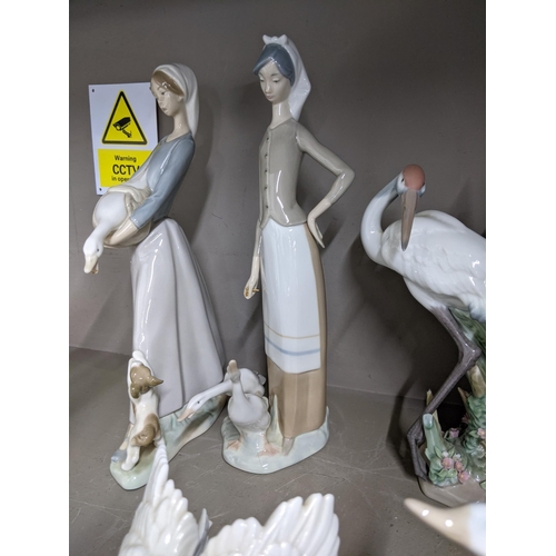 322 - Six Lladro figures to include a model of two storks, a model of a swan, a goose, a girl holding a go... 