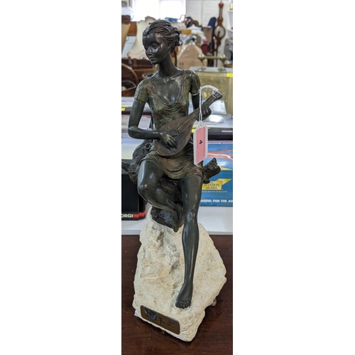 4 - A bronze composite figure of a lady playing a banjo sat on a tree stump on a naturalistic base, sign... 