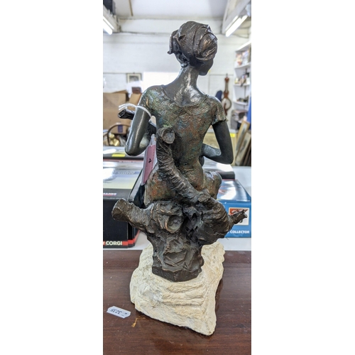 4 - A bronze composite figure of a lady playing a banjo sat on a tree stump on a naturalistic base, sign... 