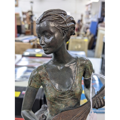 4 - A bronze composite figure of a lady playing a banjo sat on a tree stump on a naturalistic base, sign... 