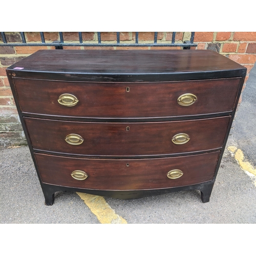 466 - A Georgian mahogany bow fronted chest of three graduated drawers with brass handles, on bracket feet... 