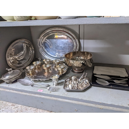 69 - A selection of silver plated items to include a punch bowl and cups with ladle, circular Sheffield p... 