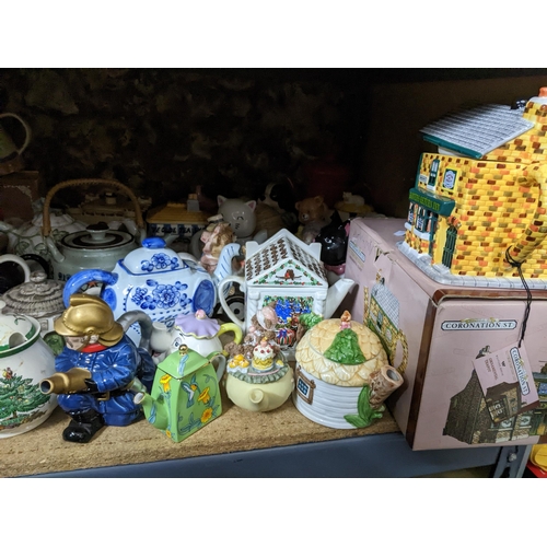 71 - A collection of novelty teapots, some boxed, to include a red telephone box teapot, and others Locat... 