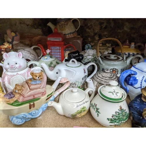 71 - A collection of novelty teapots, some boxed, to include a red telephone box teapot, and others Locat... 