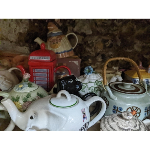 71 - A collection of novelty teapots, some boxed, to include a red telephone box teapot, and others Locat... 