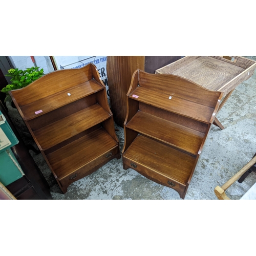 128 - Two matching mahogany small waterfall bookcases, three open shelves above a single drawer, on bracke... 