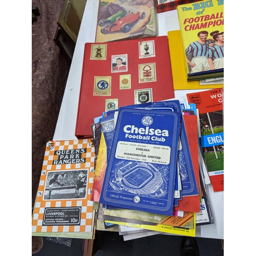 29 - A collection of sporting related printed items to include various football programmes, collectors ca... 