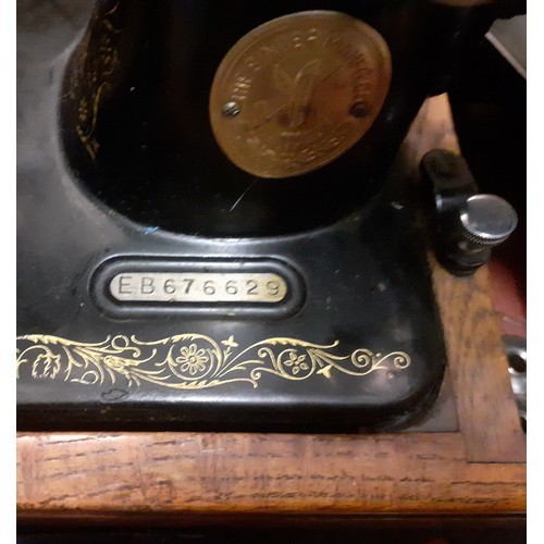 336 - A 1937 Singer 99K sewing machine, serial no:EB676629 with manual and accessories under an oak domed ... 