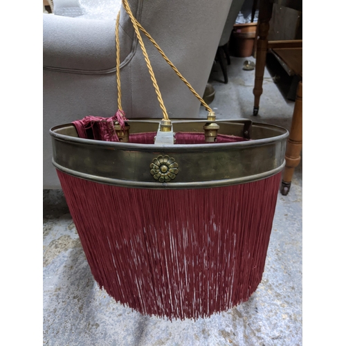 513 - A matched pair of early 20th century brass ceiling lights with burgundy fabric fringe, one a rise an... 