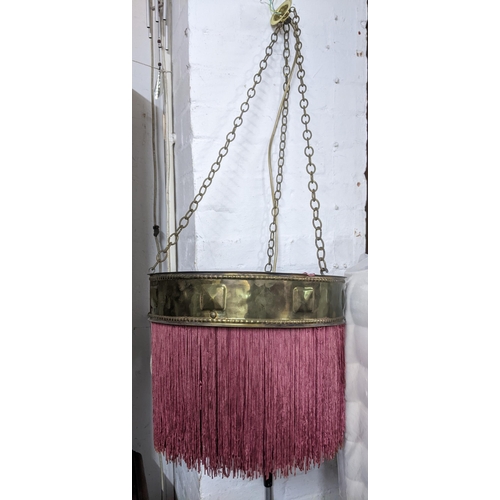 513 - A matched pair of early 20th century brass ceiling lights with burgundy fabric fringe, one a rise an... 