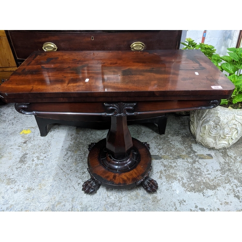 516 - A Regency mahogany folding swivel top card table, the top with circular inset baize, on fluted balus... 