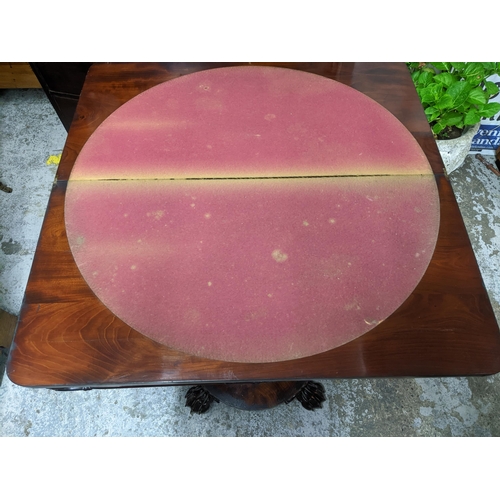 516 - A Regency mahogany folding swivel top card table, the top with circular inset baize, on fluted balus... 