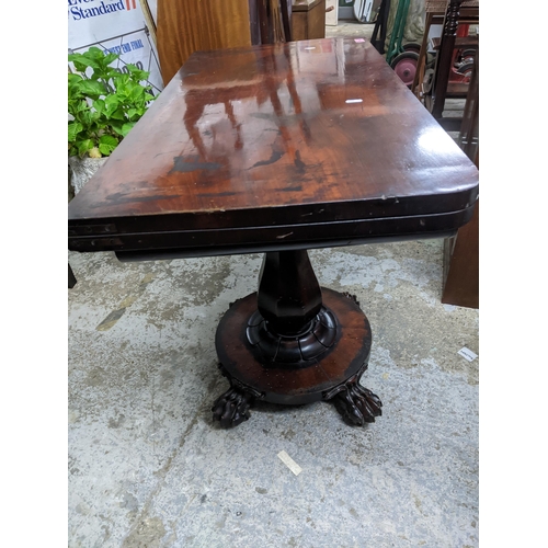 516 - A Regency mahogany folding swivel top card table, the top with circular inset baize, on fluted balus... 